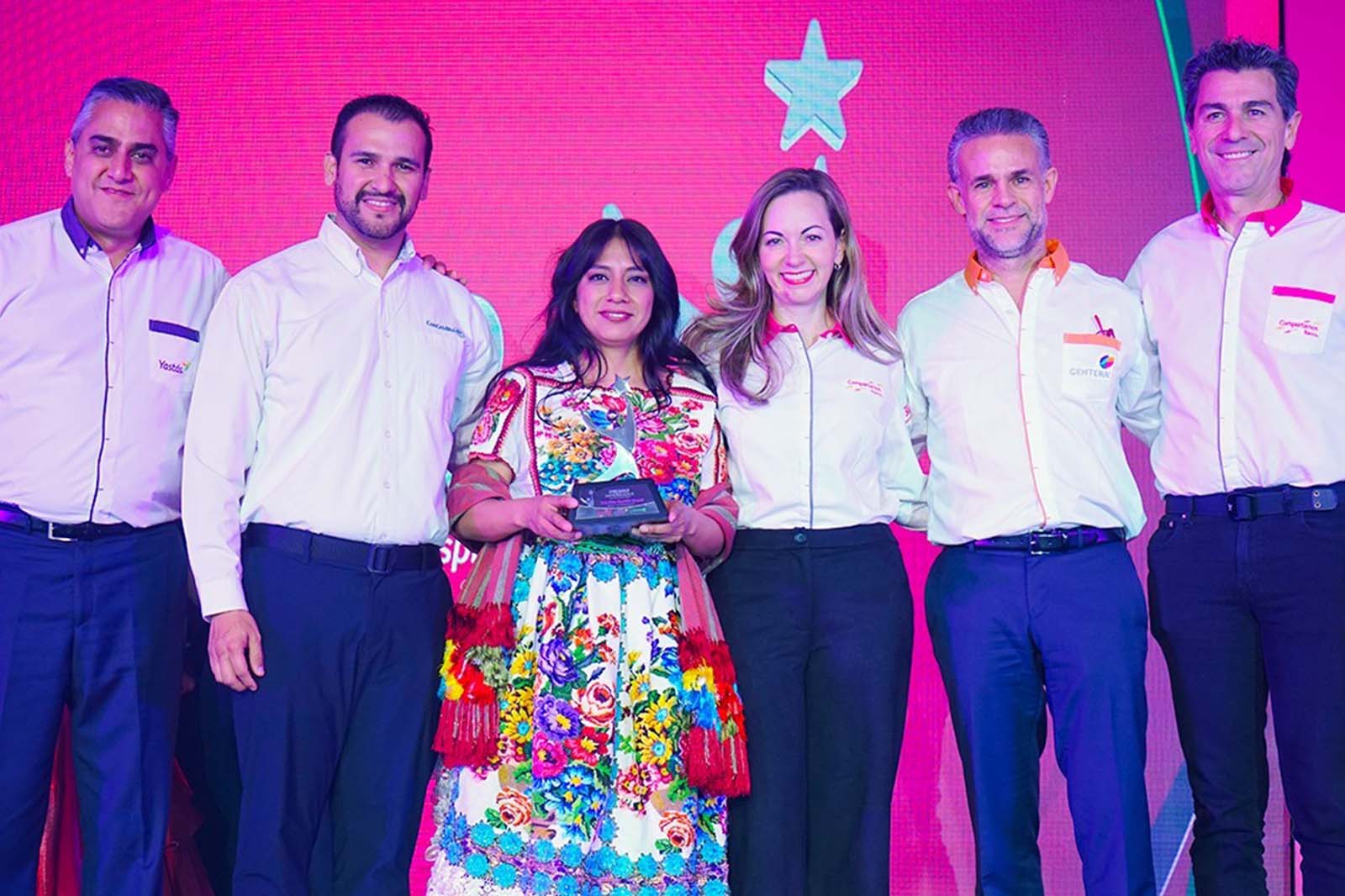 Martha Ramón posando con su trofeo, junto a representantes de Compartamos Banco y Yastás.