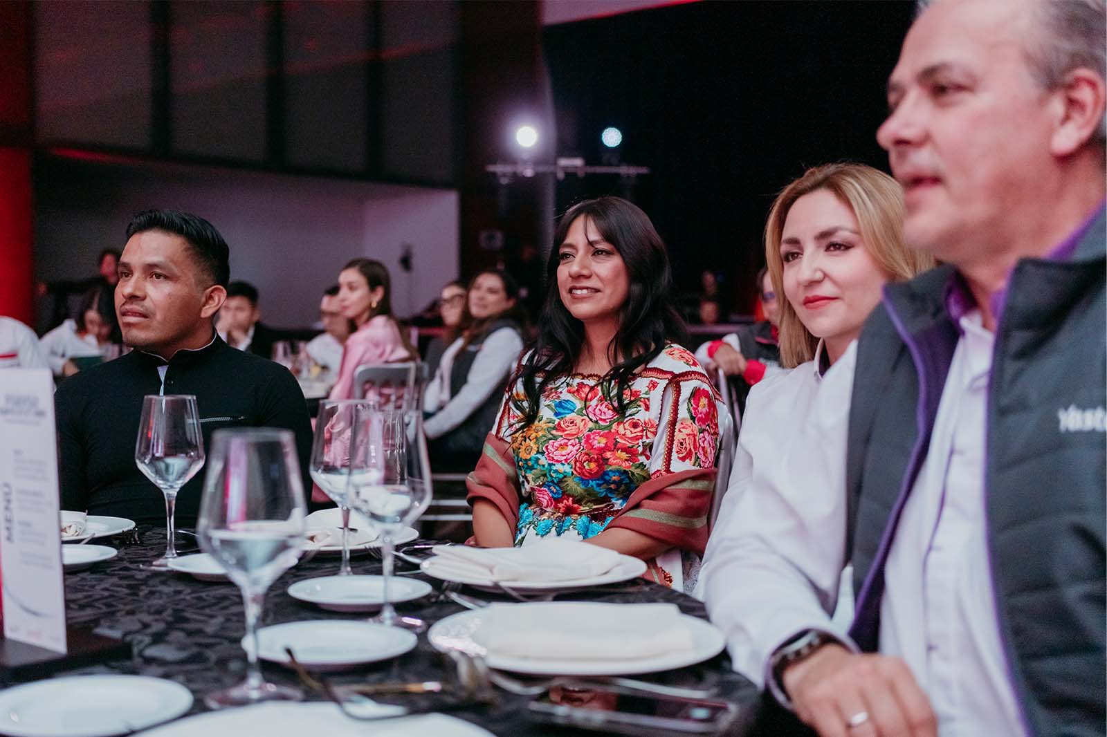 Martha Ramón en una mesa del evento, acompañada por otros asistentes de la premiación.